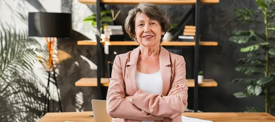 Erfaren kvinnlig VD står med armarna i kors på kontor inför strategisk VD-rekrytering 2026.