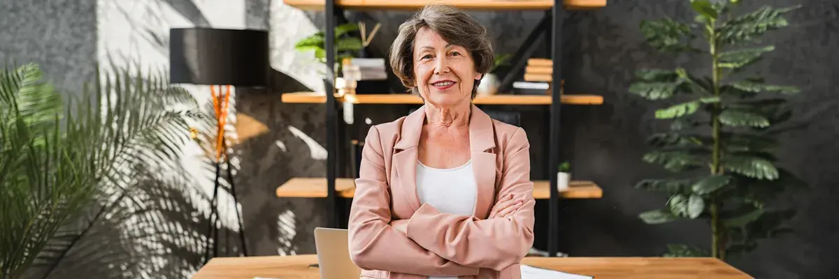 Erfaren kvinnlig VD står med armarna i kors på kontor inför strategisk VD-rekrytering 2026.